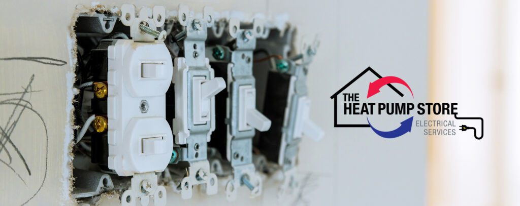 Installation of electrical switches and outlets in a newly constructed home during daylight 3 light switches without covers with The Heat Pump Store logo